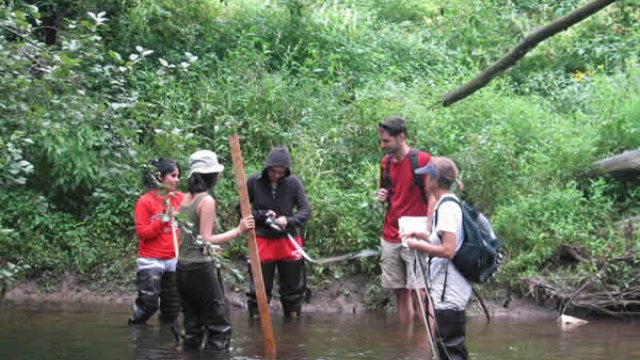 Volunteers measuring stream channel width.