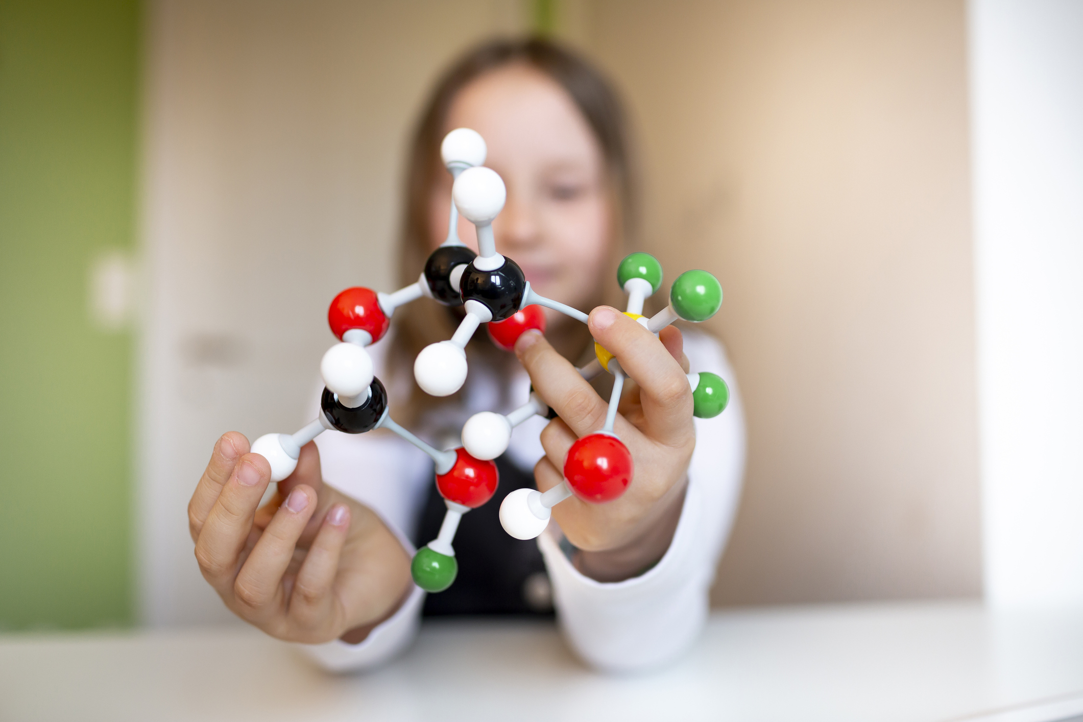 child holding a chemical molecule model