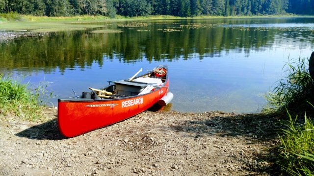 Image showing a red canoe on the shore of a lake
