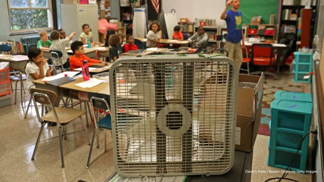 Hot classroom being cooled by large box fan. 