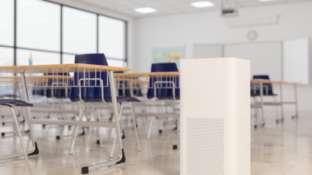 portable air cleaner in an empty classroom with desks.