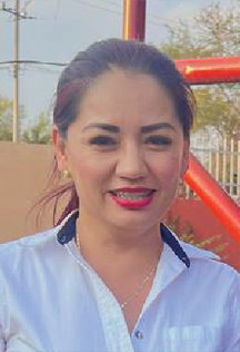 smiling latino woman with white shirt. hair in a ponytail