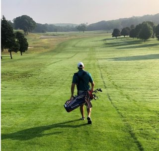 Golfer walking with his bag on a golf course