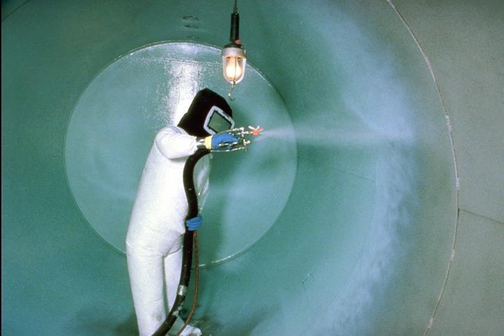 trabajador de la EPA colocando revestimiento en tanque de almacenamiento