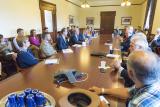 Men and women sit around a large conference table