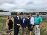 Acting Administrator Wheeler stands with 2 women and 2 men in front of a long series of solar panels