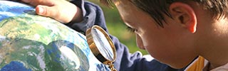 Image of a young student looking at a globe