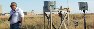 decorative photograph of a worker and site monitoring equipment in a field