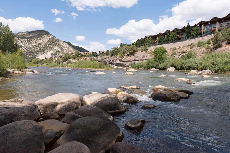 scenic photo of mountain stream with many boulders in the foreground
