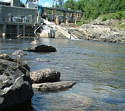 Photo showing the lower side of a dam where moving water clears sediment and the water looks clearer.