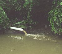 Photo showing a drain dropping water into a stream or river.