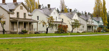 Photo showing an urban street with a row of detached houses.