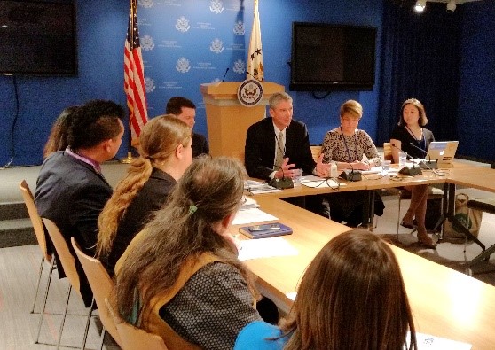 Federal officials speaking, and gathered around a table