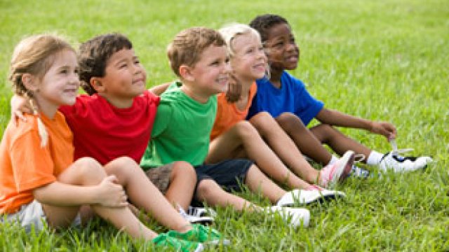 children sitting on a field of grass