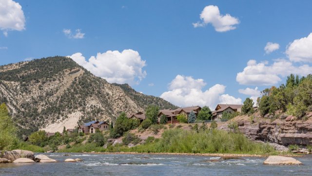 scenic view of mountain stream with houses on the opposite shore