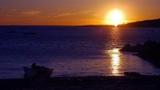 Photo of the sunset capturing a boat in Kettle Cove