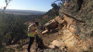 EPA Contractor in yellow vest with handheld device and backpack