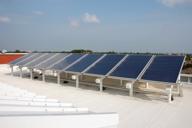 Photo: flat-plate solar collectors on the roof of a school