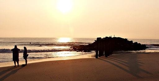 A couple on the beach at Cape Henlopen at sunset.