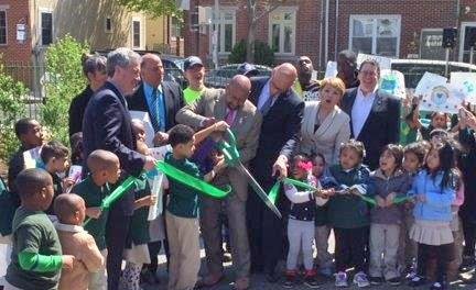 Mayor Nutter and EPA Regional Administrator Garvin cutting the ribbon surrounded by students and faculty.