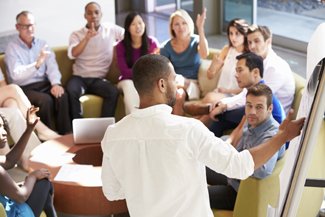 Meeting attendees looking at a whiteboard