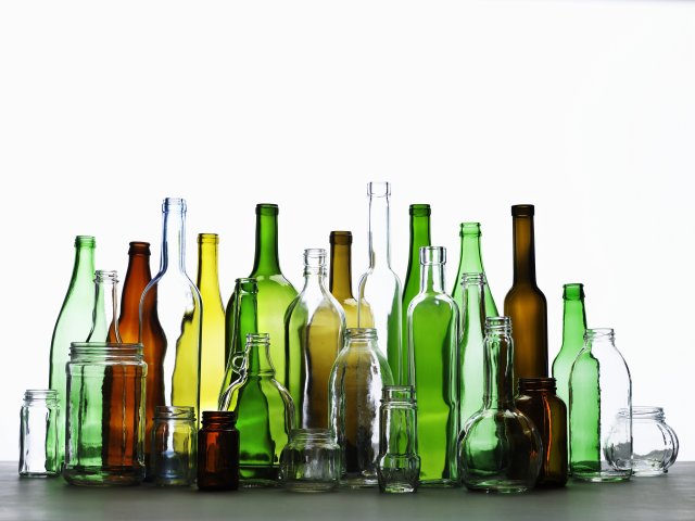 This is a picture of glass bottles of different sizes, shapes, and colors. Some are transparent while others are green, yellow and brown.