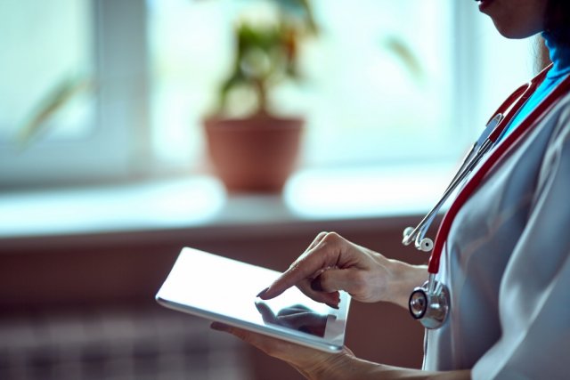 A medical professional uses a tablet