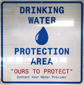 Sign says "Drinking Water Protection Area - Ours to Protect - Contact Your Water Provider"