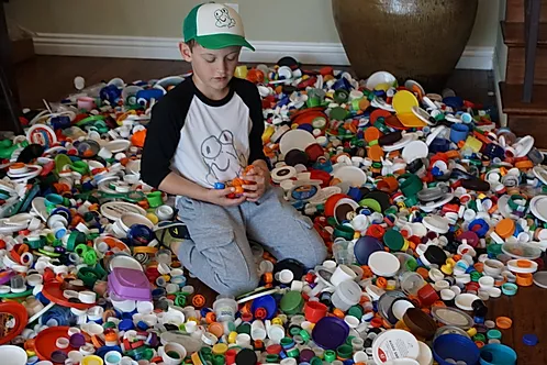 Justin Sather with a collection of plastic caps he encouraged his community to save.