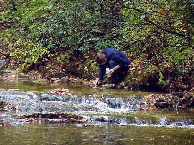 An EPA scientist testing the acidity of a stream (2004). 