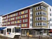 new multifamily building behind a light rail train