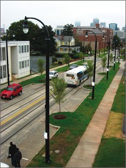 street with sidewalk, bus lane, lighting, and planted strips along street