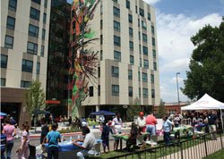 people gathering at a neighborhood event in front of the Mariposa Building
