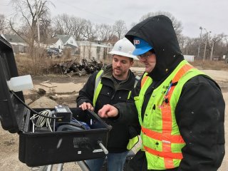 George Krebs of Illinois EPA (right), works with a contractor at an air monitoring station.