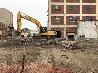 Tracked excavator cleans up asbestos debris.
