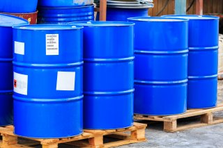 Several bright blue metal drums on a wooden pallet