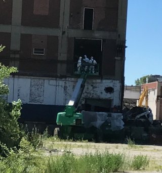 Technicians remove large pieces of cleaned metal debris.