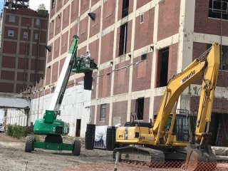 Technicians relocate the chute used to load asbestos-contaminated material into roll-off-boxes for off-site disposal.  