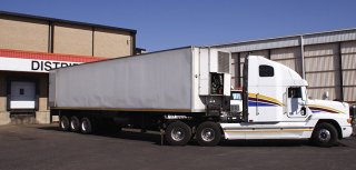 Decorative Image of a white tractor and trailer at a loading dock.