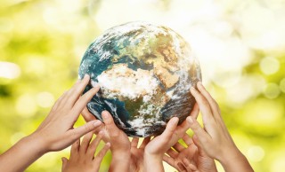 many hands holding up a globe