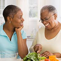 Woman and her elderly mother cooking in the kitchen