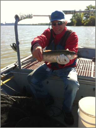 Man on a boat holding a fish