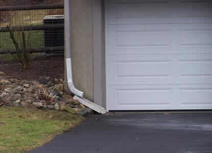 Downspout directs rain to the driveway and street