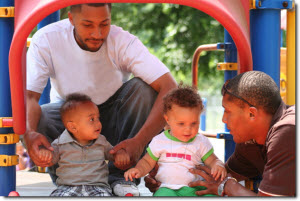two dads with their children at a playground two dads with their children at a playground
