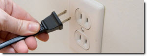 hand plugging a power cord into an outlet
