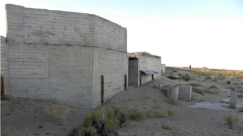 Concrete structure called an “Upgrader”, meant to increase the concentration of uranium in the ore from local mines. Concrete structure in a desert landscape