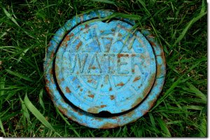 cap for a groundwater pipe surrounded by green grass