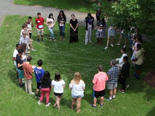 Kids stand in a circle learning a lesson about the environment
