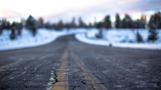 damaged asphalt road amid a snowy terrain