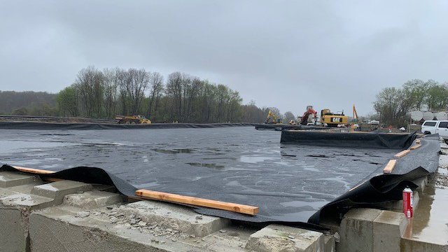 Soil waste pile lined with thick pastic and concreete barriers